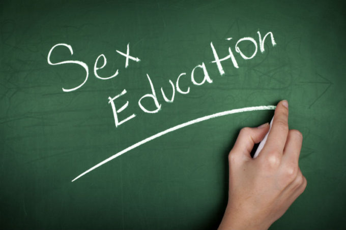 una mano scrive su una lavagna sex education, educazione sessuale
