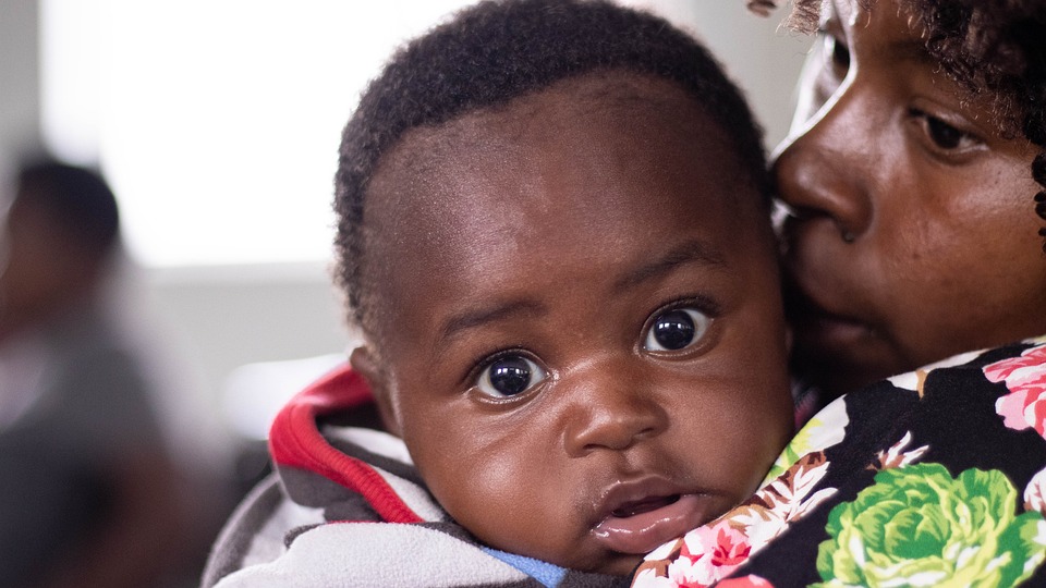 Un bambino piccolo nero con la mamma